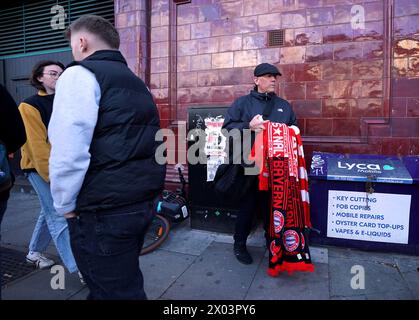 Un venditore di foulard di mezza e mezza partita vicino al terreno davanti ai quarti di finale di UEFA Champions League, partita di andata tra Arsenal e Bayern Monaco all'Emirates Stadium di Londra. Data foto: Martedì 9 aprile 2024. Foto Stock