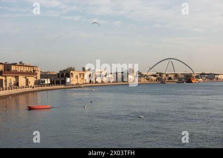 Guardando attraverso il torrente dal quartiere storico di al Shindagha verso il Ponte dell'Infinito a Bur Dubai, Emirati Arabi Uniti. Foto Stock