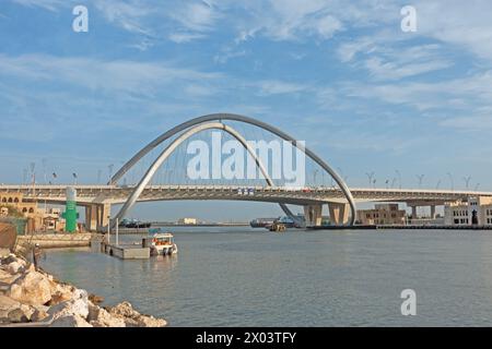 Guardando attraverso il torrente dal quartiere storico di al Shindagha verso il Ponte dell'Infinito a Bur Dubai, Emirati Arabi Uniti. Foto Stock