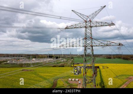 Wiefelstede, Germania. 09 aprile 2024. Sono in corso lavori di costruzione di nuovi tralicci elettrici vicino alla sottostazione di Conneforde. (Vista aerea con un drone) il ministro dell'ambiente della bassa Sassonia Meyer esamina i progressi dell'espansione della rete elettrica nella bassa Sassonia e visita un cantiere in pilone per il progetto di transizione energetica, che mira ad aumentare la capacità di trasmissione nella bassa Sassonia nordoccidentale. Credito: Sina Schuldt/dpa/Alamy Live News Foto Stock