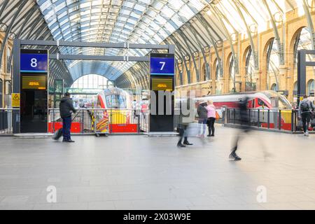 Londra, Regno Unito - 24 marzo 2024; ombre rallentate dei passeggeri che camminano verso i treni Azuma alla stazione ferroviaria di Kings Cross Foto Stock