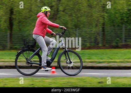 Bielefeld, Germania. 09 aprile 2024. Una ciclista cavalca il suo pedelec attraverso un'area di allenamento per il traffico. La polizia di Bielefeld offre corsi di formazione per pedelec insieme all'ADFC e al centro di educazione per adulti. Il corso è rivolto agli anziani di età pari o superiore ai 60 anni. Oltre a sensibilizzare in merito a situazioni di traffico poco chiare e pericolose, l'obiettivo è quello di addestrare la guida sicura e l'uso sicuro del proprio pedelec. Credito: Friso Gentsch/dpa/Alamy Live News Foto Stock