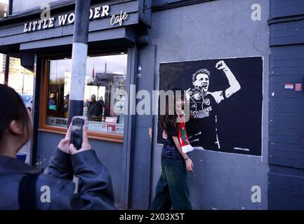 Tifosi dell'Arsenal con illustrazioni di Martin Odegaard dell'Arsenal vicino al terreno davanti ai quarti di finale della UEFA Champions League, partita di andata e ritorno tra l'Arsenal e il Bayern Monaco all'Emirates Stadium di Londra. Data foto: Martedì 9 aprile 2024. Foto Stock