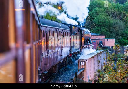 Treno passeggeri trainato da locomotiva a vapore che parte dalla stazione di Keighley sulla Keighley and Worth Valley Railway, Yorkshire, Inghilterra. Foto Stock