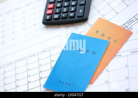 Opuscoli di assicurazione pensionistica giapponese sul tavolo con calcolatrice sul tavolo da vicino Foto Stock