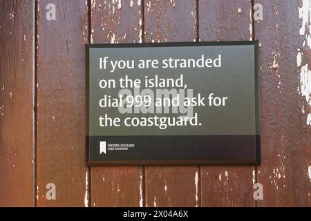 Un segnale di sicurezza, scritto da Historic Scotland, sul Brough di Birsay, per tutte le persone che rimangono bloccate sull'isola. Foto Stock