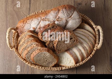 Diversi tipi di pane nel cestello in vimini su un tavolo in legno, vista dall'alto Foto Stock