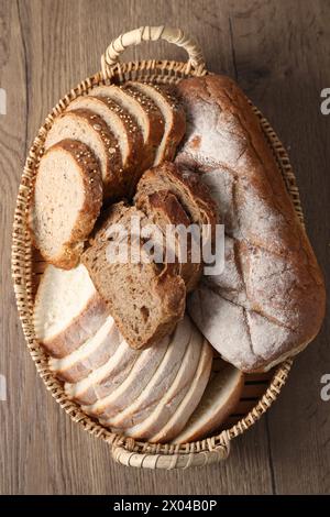 Diversi tipi di pane nel cestello in vimini su un tavolo in legno, vista dall'alto Foto Stock