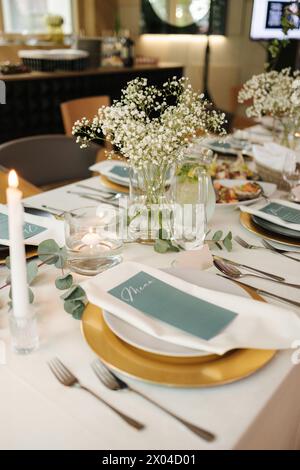 Il tavolo per matrimoni nel ristorante era bellissimo ed elegante. Gypsophila ed eucalipto. Tavolo servito. Foto Stock