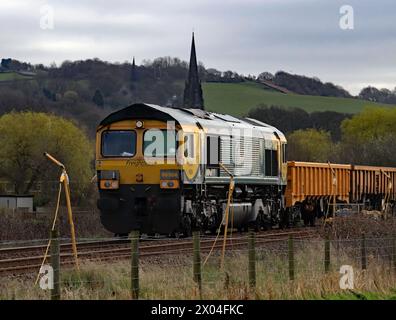 La locomotiva diesel 66504 di linea merci scorre lentamente verso il passaggio a livello di Culvert Lane tra Parbold e Hoscar con un treno di vagoni vuoti Foto Stock