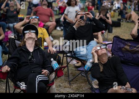 Kerrville, Stati Uniti d'America. 8 aprile 2024. Kerrville, Stati Uniti d'America. 8 aprile 2024. Gli spettatori che indossano occhiali protettivi guardano in alto mentre la luna copre la parte anteriore del Sole durante la festa di osservazione dell'eclissi solare, 8 aprile 2024, a Kerrville, Texas. Un'eclissi solare totale ha attraversato una stretta porzione del continente nordamericano dal Messico alla costa atlantica di Terranova, in Canada. Crediti: Aubrey Gemignani/NASA/Alamy Live News Foto Stock