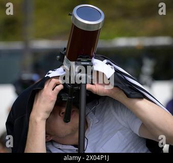 Washington, Stati Uniti d'America. 8 aprile 2024. Washington, Stati Uniti d'America. 8 aprile 2024. Un uomo copre il suo telescopio con filtri protettivi mentre scatta una foto dell'eclissi solare durante una festa di osservazione al National Mall, l'8 aprile 2024, a Washington, DC Un'eclissi solare totale ha attraversato una stretta porzione del continente nordamericano dal Messico alla costa atlantica di Terranova, in Canada. Crediti: Bill Ingalls/NASA/Alamy Live News Foto Stock