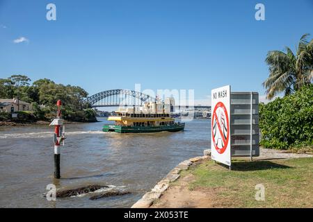 Il traghetto di Sydney The Golden Grove passa tra il marcatore di navigazione del porto e Goat Island sul porto di Sydney, Port Jackson, Sydney, Australia Foto Stock