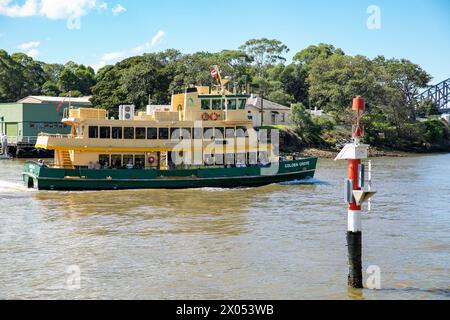 Il traghetto di Sydney chiamato Golden Grove passa per Goat Island sul porto di Sydney, e un indicatore di navigazione del porto rosso, Sydney, NSW, Australia Foto Stock