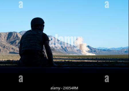 Un Airman degli Stati Uniti assegnato al 757th Aircraft Maintenance Squadron assiste a un'esplosione durante un addestramento di addestramento di competenza del Joint Terminal Attack Controller presso il Nevada test and Training Range, il 2 aprile 2024. Diverse munizioni, tra cui 65 missili aria-terra Maverick, unità bomba guidata (GBU) 39 bombe di piccolo diametro e munizioni di attacco diretto congiunte GBU-31, furono sganciate durante l'addestramento. (Foto U.S. Air Force di Jose Miguel T. Tamondong, Senior Airman) Foto Stock