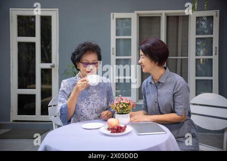 Felice madre asiatica con sua figlia adulta sono rilassati a parlare insieme al mattino. Foto Stock