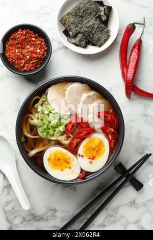 Delizioso ramen in ciotola servito su un tavolo di marmo bianco, piatto. Zuppa di noodle Foto Stock