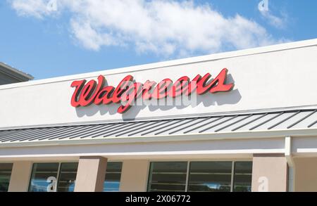 Ocala, Florida 4-9-2024 Walgreens Drug Store logo rosso, cartellonistica, ingresso esterno della facciata con cielo blu e sfondo nuvoloso. Walgreens è americano Foto Stock