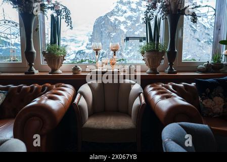 Lussuoso design interno con vista sulle montagne e divani Chesterfield in un ambiente ad alta quota Foto Stock