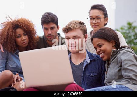 Gruppo di studenti, campus e laptop con Diversity o International e learning, collaborazione o ricerca. Lavoro di squadra, studio e persone Foto Stock