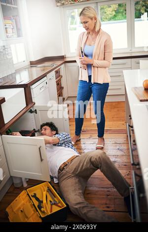 Idraulico, lavoratore e donna che guarda stressato per riparazioni di tubi, perdite di lavandini e manutenzione della cucina. Signora, preoccupato e tuttofare con gli strumenti per sistemare Foto Stock