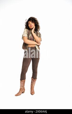 sofisticata donna afroamericana in abbigliamento con stampa animalistica su sfondo bianco che guarda lontano Foto Stock