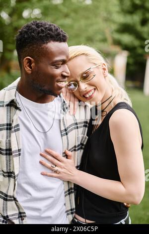 Una felice coppia multiculturale che si riunisce all'aperto in un parco. Foto Stock