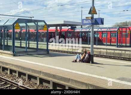 Una donna backpacker attende il treno alla stazione di Buchloe il 27 marzo 2024 ad Augusta, Germania © Peter Schatz / Alamy Stock Photos Foto Stock