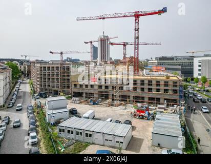 Lipsia, Germania. 09 aprile 2024. Nel cantiere di Krystallpalast si trovano diverse gru. Un nuovo complesso di edifici composto da quattro edifici a 4-6 piani e un cortile interno pubblico e' stato costruito su un terreno di circa 18.000 metri quadrati vicino al centro citta'. (Vista aerea con drone) credito: Jan Woitas/dpa/Alamy Live News Foto Stock