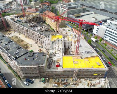 Lipsia, Germania. 09 aprile 2024. Nel cantiere di Krystallpalast si trovano diverse gru. Un nuovo complesso di edifici composto da quattro edifici a 4-6 piani e un cortile interno pubblico e' stato costruito su un terreno di circa 18.000 metri quadrati vicino al centro citta'. (Vista aerea con drone) credito: Jan Woitas/dpa/Alamy Live News Foto Stock