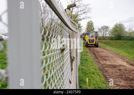 Katterbach, Germania. 10 aprile 2024. I veicoli da cantiere sono parcheggiati come parte di una misura di bonifica PFAS sulla base del campo di aviazione militare americano di Katterbach, vicino ad Ansbach. Nel 2014 sono state rilevate sul sito le cosiddette sostanze chimiche per- e polifluorurate (PFAS), originate dalla schiuma antincendio utilizzata in un'ex area di addestramento antincendio. Al fine di prevenire la propagazione delle acque sotterranee contaminate e di pulirle, sono state avviate diverse misure di bonifica. Crediti: Daniel Karmann/dpa/Alamy Live News Foto Stock