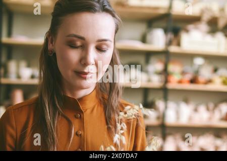 Ritratto di una bella donna ceramista in uno studio di ceramica, professione creativa Foto Stock