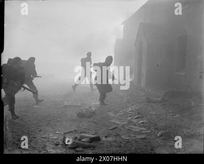 COMMANDOS BELGI IN ADDESTRAMENTO IN GRAN BRETAGNA, 1945 - sotto copertura di fumo, un gruppo di Commandos belgi assaltano un edificio come parte di un esercizio di addestramento, da qualche parte in Gran Bretagna Foto Stock