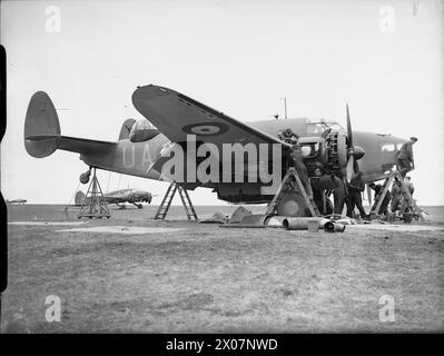 COMANDO COSTIERO DELLA ROYAL AIR FORCE, 1939-1945. - Equipaggio al servizio della Lockheed Hudson Mark i, N7303 'UA-B', del No.269 Squadron RAF a Wick, Caithness. L'aereo è stato messo in sicurezza in posizione di volo per testare le mitragliatrici a fuoco in avanti contro i colpi di arma da fuoco. Un Avro Anson Mark i, K6244, anch'esso dello Squadron, può essere visto alla sinistra della Royal Air Force, 269 Squadron Foto Stock