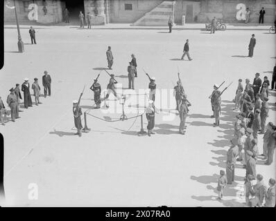 LA ROYAL NAVY DURANTE LA SECONDA GUERRA MONDIALE - Maltese classifica il cambio di guardia con il King's Own Malta Regiment in Palace Square mentre la George Cross è esposta cerimonialmente in Palace Square, la Valletta, nel primo anniversario di Malta, ricevette la George Cross da sua Maestà Re Giorgio vi il 15 aprile 1942 Foto Stock