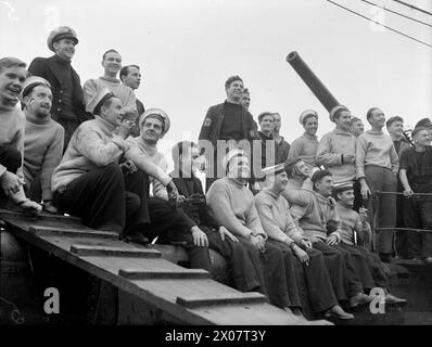 IL SOTTOMARINO SERAPH E' A CASA DOPO 13 MESI DI LAVORO. 24 DICEMBRE 1943, PORTSMOUTH. IL SUO COMANDANTE, IL TENENTE N L A JEWELL, RN, È STATO INSIGNITO DEL MBE PER I SERVIZI SPECIALI CON IL GENERALE MARK CLARK DELL'ESERCITO AMERICANO, CHE SBARCÒ SEGRETAMENTE SULLA COSTA ALGERINA, PERMETTENDOGLI DI ENTRARE IN CONTATTO CON I LEADER FRANCESI PRO-ALLEATI E PREPARARE LA STRADA PER GLI SBARCHI ALLEATI IN NORD AFRICA. - L'equipaggio sorridente DEL SERAPH riconosce la casa di benvenuto degli amici che aspettano sul molo Foto Stock