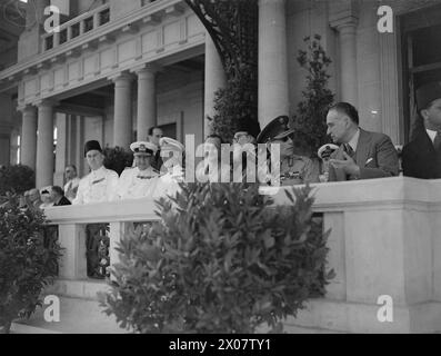 Il comandante in capo del Mediterraneo, il re greco e i funzionari osservarono un passato di marcia delle associazioni greche di Alessandra, compresi gli ufficiali di polizia e di marina e i leader religiosi. Foto Stock