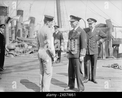 NORE C-IN-C VISITA IL SOTTOCOMANDO DI HARWICH. 20 LUGLIO 1943. AMMIRAGLIO SIR JOHN C TOVEY, KCB, KBE, DSO, NUOVO C-IN-C NORE, HO FATTO UNA VISITA NON CERIMONIALE AL SOTTOCOMANDO DI HARWICH. FU ACCOMPAGNATO NEL SUO TOUR DAL CONTRAMMIRAGLIO H H ROGERS, MVO, OBE. Ammiraglio Sir John Tovey, saluto un vecchio compagno di nave. Durante la sua passeggiata lungo la banchina, l'ammiraglio Sir John Tovey ha riconosciuto A/B C W Simmonds, che ha prestato servizio con lui a Chatham 10 anni fa, e che ora lavora come membro dell'equipaggio delle pompe del fuoco. Il contrammiraglio H H Rogers guarda avanti Foto Stock