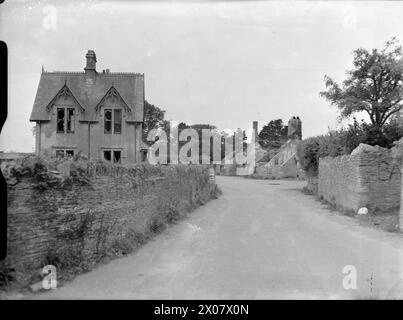 US BATTLE TRAINING AREA, DEVON, INGHILTERRA, Regno Unito, SETTEMBRE 1944 - Una strada nel villaggio di Strete, Devon, che mostra i danni causati durante le esercitazioni di addestramento in preparazione allo sbarco del D-Day. Le finestre della casa a sinistra non hanno vetri, e gli edifici a destra, compreso il vecchio Istituto femminile, sono stati quasi completamente distrutti. La didascalia originale indica che l'edificio WI è stato bruciato. La strada corre lungo la cima della scogliera ed era nella linea di tiro dei bombardamenti navali Foto Stock