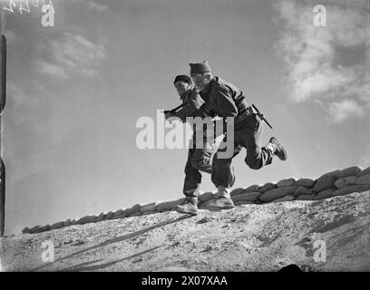 Due Comandanti navali della Royal Navy caricano in avanti con i cannoni raccolti durante l'addestramento presso la HMS Saunders, Kabrit, vicino a Bitter Lakes nel Mediterraneo, seconda guerra mondiale Foto Stock