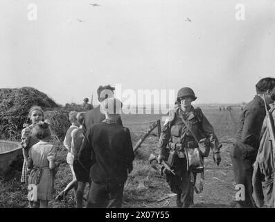 I bambini olandesi salutano i paracadutisti del 506th Parachute Infantry Regiment, US 101st Airborne Division, dopo l'atterraggio nella zona di lancio B vicino a Son durante l'operazione Market Garden, 17 settembre 1944. Foto Stock