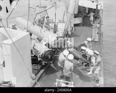 LA TRIPLICE CELEBRAZIONE DELLA HMS WOLVERINE. MARZO 1944, FREETOWN. LA HMS WOLVERINE, UNA DESTROYER DI 25 ANNI, HA RECENTEMENTE CELEBRATO TRE "COMPLEANNI" SPECIALI. HA PERCORSO 200.000 MIGLIA DALL'INIZIO DELLA GUERRA, HA COMPLETATO UN ANNO DI SERVIZIO NELLA STAZIONE DELL'AFRICA OCCIDENTALE E HA APPENA PORTATO IL SUO 100° CONVOGLIO IN SICUREZZA A HARBOR. - Caricare i tubi siluro a bordo della HMS WOLVERINE Foto Stock