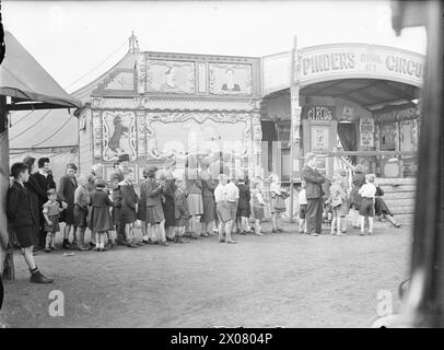 INTRATTENIMENTO IN TEMPO DI GUERRA GLASGOW, SCOZIA, 1943 - uomini, donne e bambini fanno la fila fuori Pinders Circus su Glasgow Green, 1943 Foto Stock