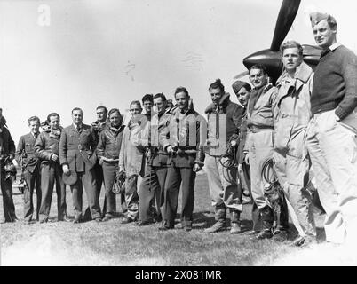 OPERAZIONI DELLA ROYAL AIR FORCE SU ALBANIA E GRECIA, 1940-1941. - Piloti del No. 33 Squadron RAF, a Larissa, Grecia, con Hawker Hurricane Mark i, V7419, in background. Essi sono (da sinistra a destra); pilota ufficiale P R W Wickham, Flying Officers D T Moir, e V C 'Woody' Woodward, Flight Lieutenant J M 'Pop' Littler, Flying Officers e H 'Dixie' Dean, F Holman (k.i.a. 20 aprile 41), e F 'Timber' Woods (k.i.a. 17 giugno 1941), Pilot Officer C A C Chetham (k.i.a. 15 aprile 1941), Flight Lieutenant A M Young, Squadron leader M St.J 'Pat' Pattle (Squadron Commanding Officer, k.i.a. 20 aprile 1941), Flying Foto Stock