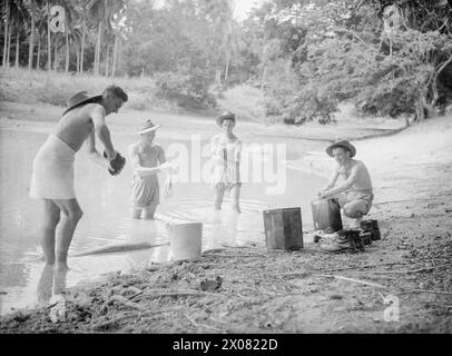 MOMENTI TROPICALI. 7 E 8 AGOSTO 1945, HMS RAJALYIA, ROYAL NAVAL AIR STATION PUTTALAM, CEYLON. ATTIVITÀ E PERSONALITÀ ALLA ROYAL NAVAL AIR STATION. - Lavare i loro "piccoli" in una piscina nella giungla a Ceylon sono i Marine e Hopkins di Newport, Monmouthshire; il Caporale dei Marines J Walton di Wolverhampton; la Marine G Hall di Pendelbury, Manchester e la Marine W Will di Rosyth Foto Stock