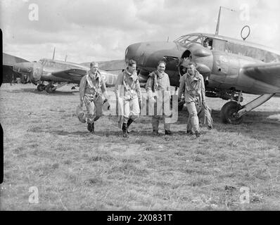 COMANDO COSTIERO DELLA ROYAL AIR FORCE, 1939-1945. - I piloti del No. 320 (olandese), o 321 (olandese) Squadron RAF camminano fino al loro Avro Anson Mark è a Carew Cheriton, Pembrokeshire. Entrambi gli Squadron furono formati il 1 giugno 1940 dai membri del Royal Netherlands Naval Air Service che erano fuggiti nel Regno Unito dopo l'invasione dell'Olanda. Il 320 Squadron, di base a Leuchars, Fife, si unì al 321 Squadron, che stava già pilotando Ansons a Carew Cheriton, e che forniva 320 Squadron con equipaggi. Un Anson sullo sfondo porta ancora le lettere del codice unità ('OY') del No. 48 Squadron RAF, con Foto Stock