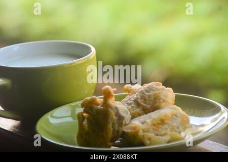 vista ravvicinata delle banane fritte e del caffè caldo. banane fritte accompagnate da caffè caldo la mattina sulla terrazza della casa. Un'abitudine fatta da Ind Foto Stock