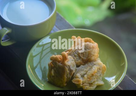 vista ravvicinata delle banane fritte e del caffè caldo. banane fritte accompagnate da caffè caldo la mattina sulla terrazza della casa. Un'abitudine fatta da Ind Foto Stock