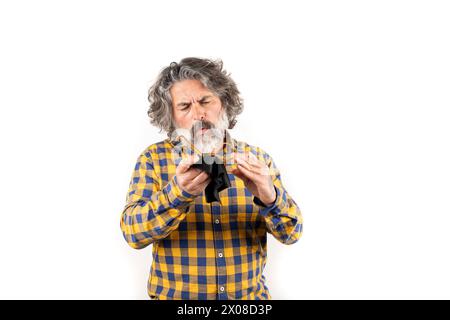 uomo di mezza età che pulisce lenti sporche per occhiali su sfondo bianco Foto Stock