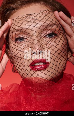 Una giovane donna con un velo che copre il suo volto, trasuda bellezza classica e mistero in un ambiente da studio. Foto Stock